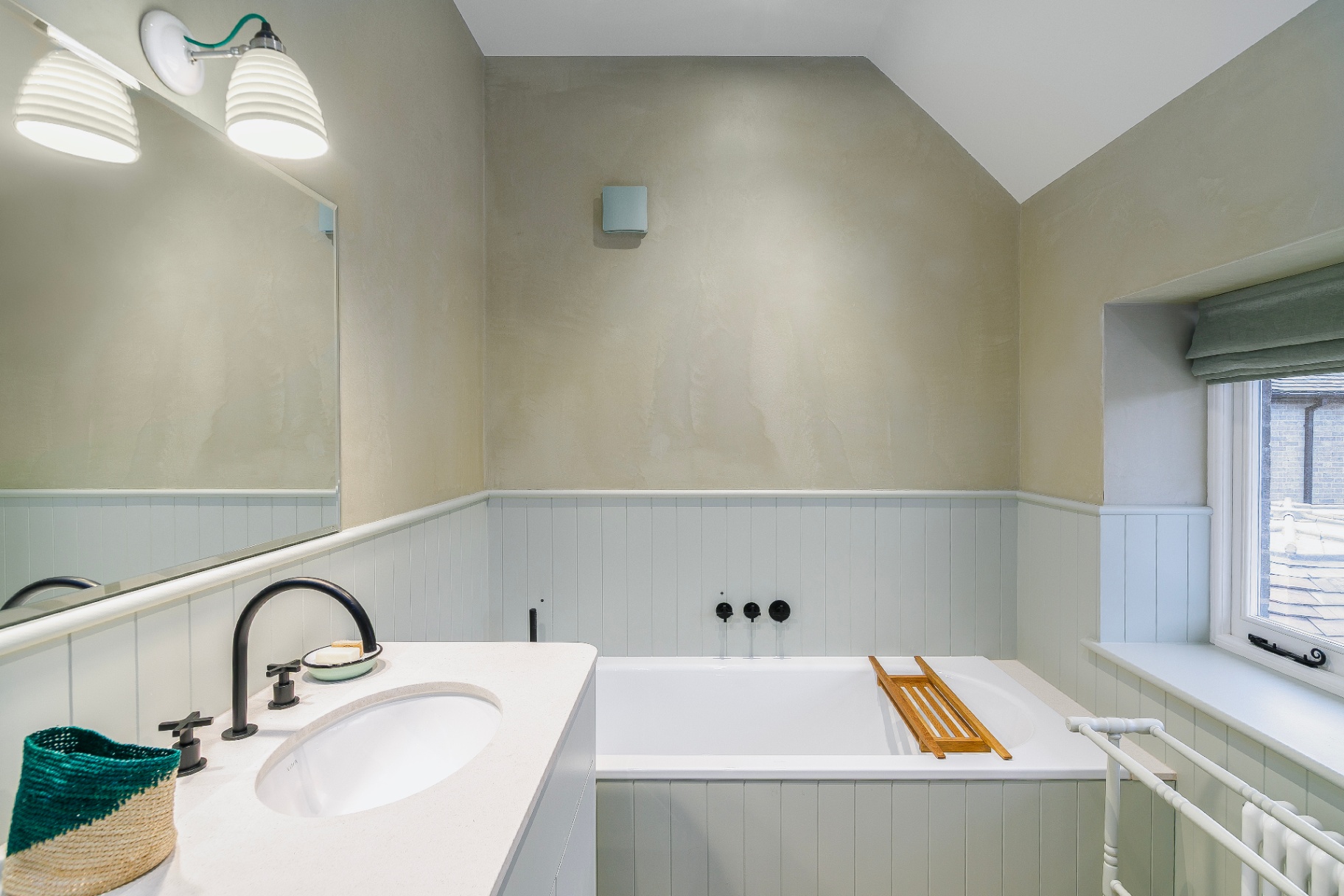 Richmond bathroom with freestanding bath, pale green panelling and white vanity